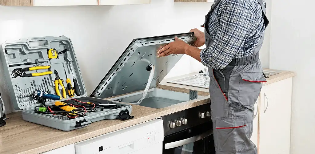 Handyman repairing a cooktop and checking wiring connections in Lincoln, NE
