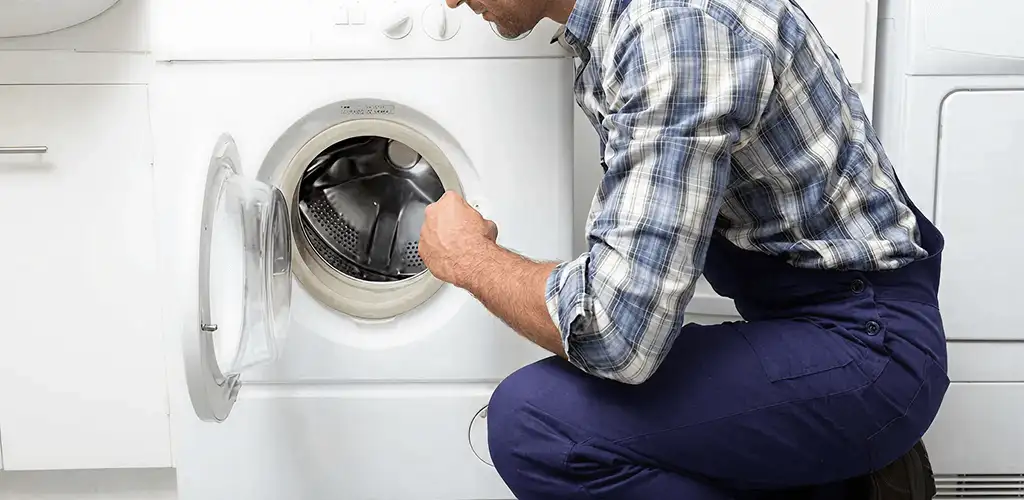 Handyman inspecting a dryer drum and internal parts for repair in Lincoln, NE